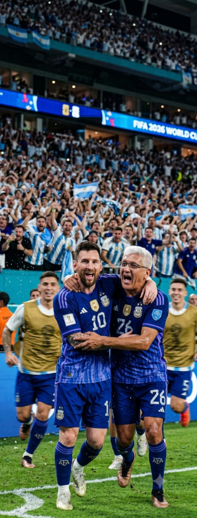 El prompt solicita una fotografía de acción hiperrealista que captura un momento de celebración eufórica en la Copa Mundial FIFA 2026. El usuario es retratado celebrando un gol en conjunto con el capitán de la Selección Argentina, rodeado por otros compañeros de equipo que se suman a la escena. Se busca una estética de reportaje documental deportivo, enfatizando la química natural entre los jugadores, la intensidad del momento y una calidad técnica de alta gama (Canon EOS R3, lente 85mm) que incluya detalles como gotas de sudor y desenfoque de movimiento.
